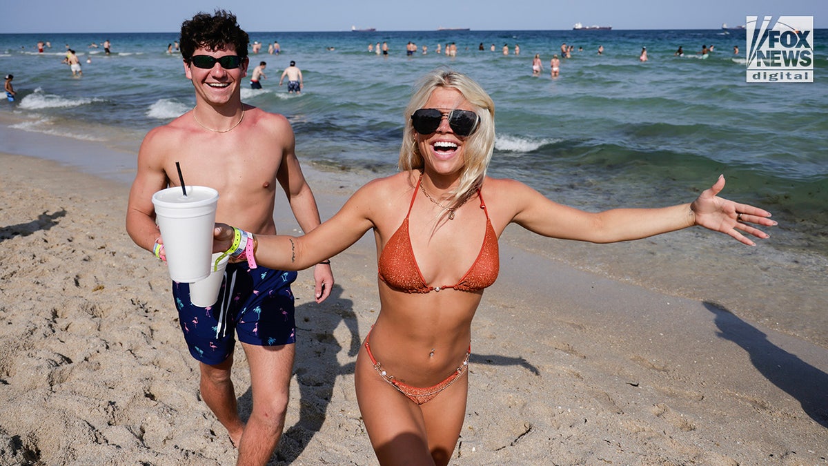 A pair of spring breakers pose along the shoreline on Fort Lauderdale Beach