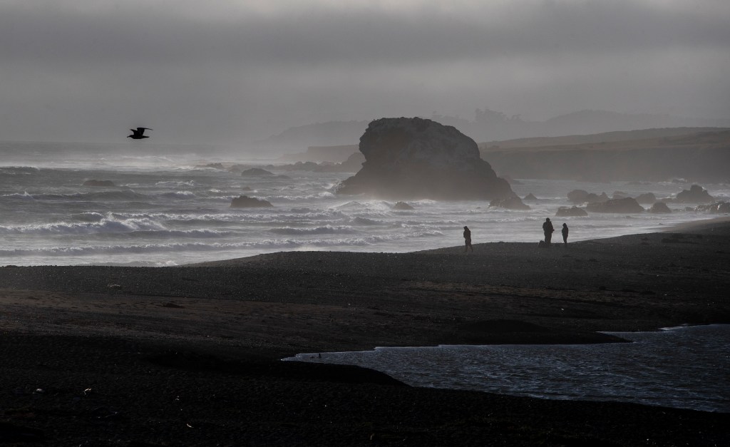 Beachgoers are seen on the sand at San Carpoforo Creek Beach along California Highway. 