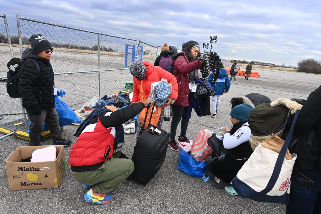 New York-Migrants pick out clothes from a donation outside the Floyd Bennett Field