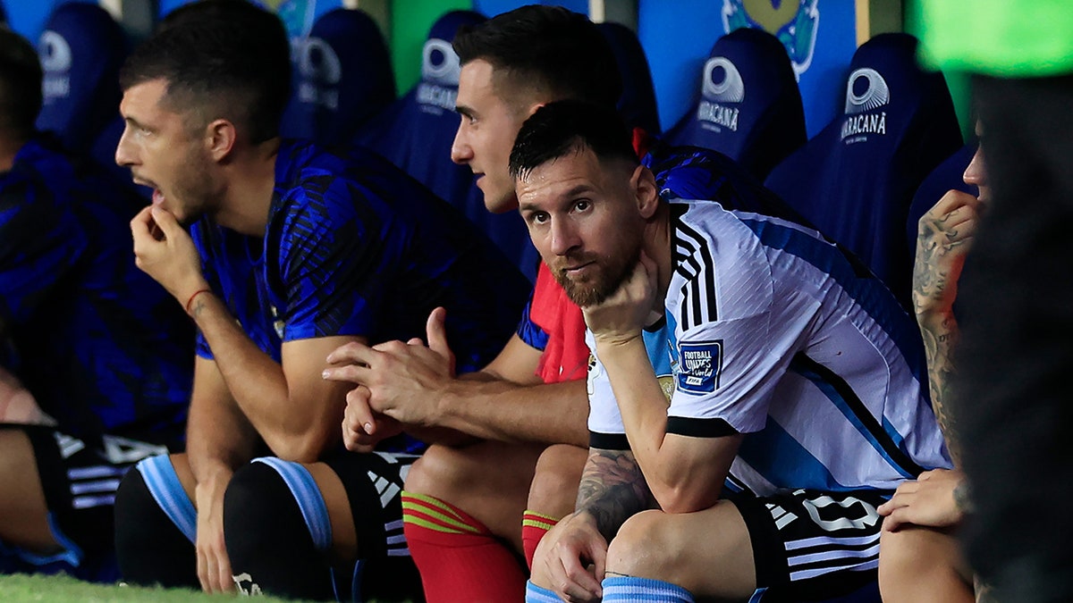 Lionel Messi looks on from the bench