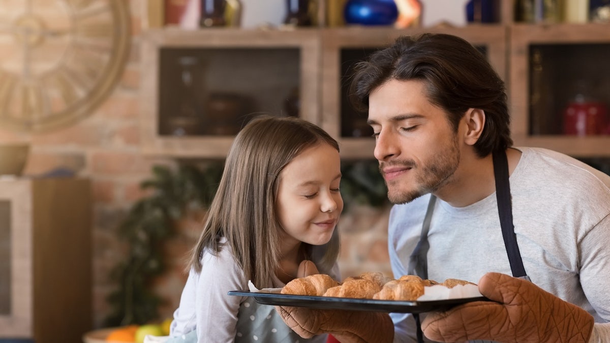 Man and girl smelling croissants