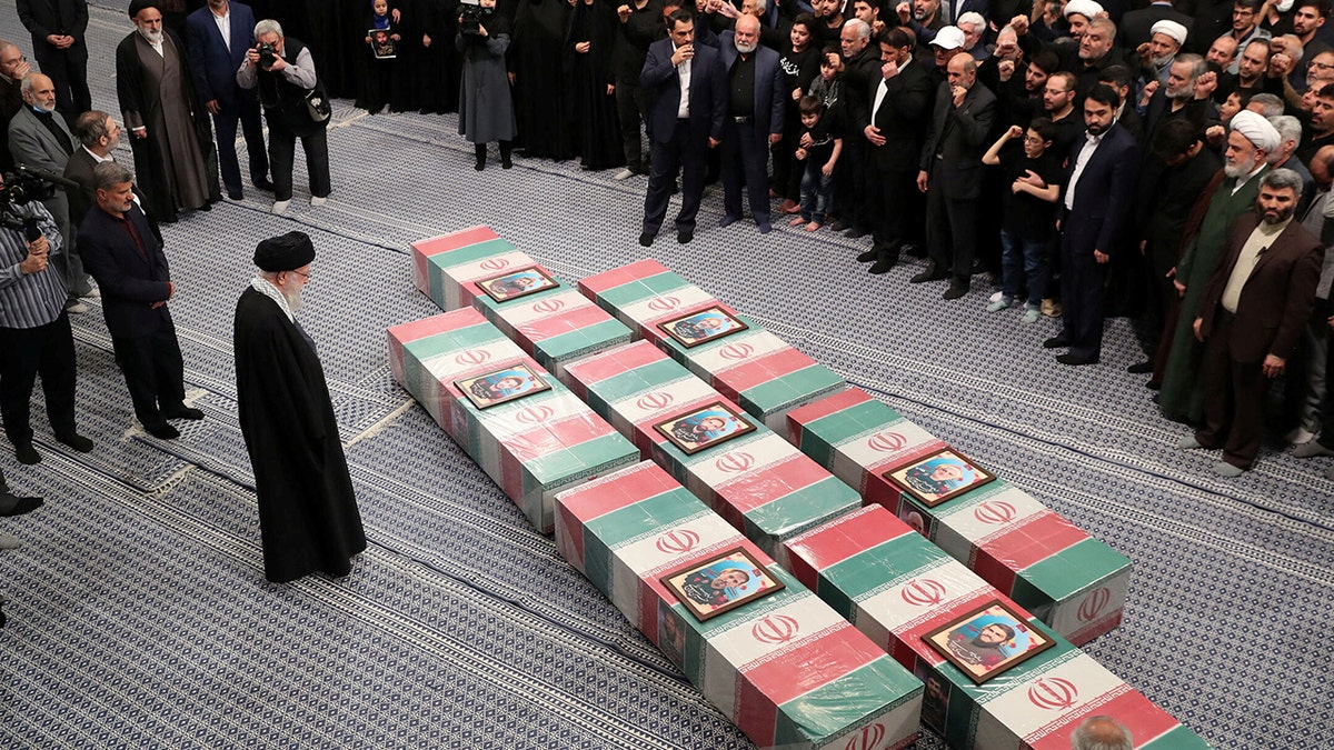 Ayatollah Ali Khamenei looking at coffins 