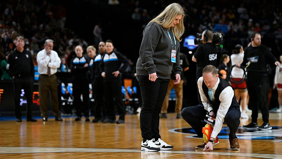 NCAA officials measure three-point line